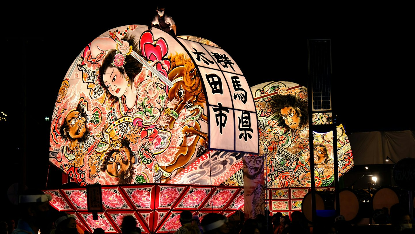 夜に伝統芸術で飾られた、照らされた日本の祭り山車。